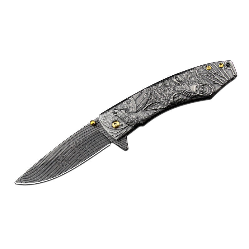 Folding knife with wolf engraved design on a white background