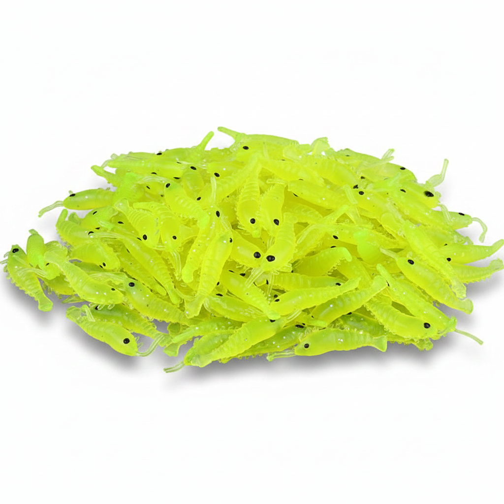 A pile of neon chartreuse green plastic fishing lures shaped like small shrimp or crawfish, with tiny black eyes, photographed on a clean white background.