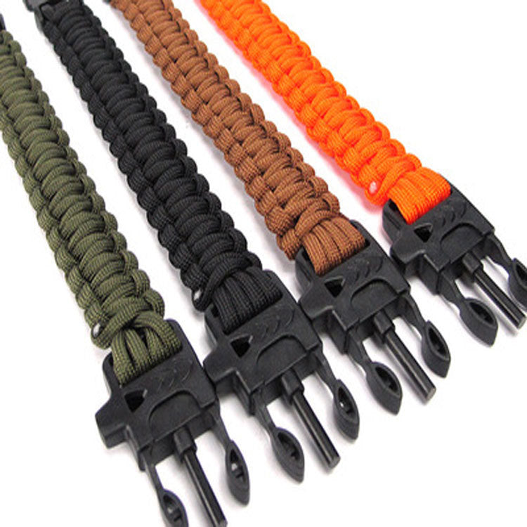 Four paracord bracelets in green, black, brown, and orange on a white background