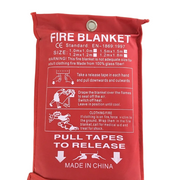 A red fire blanket with printed white instructions and product details, photographed against a plain white background.